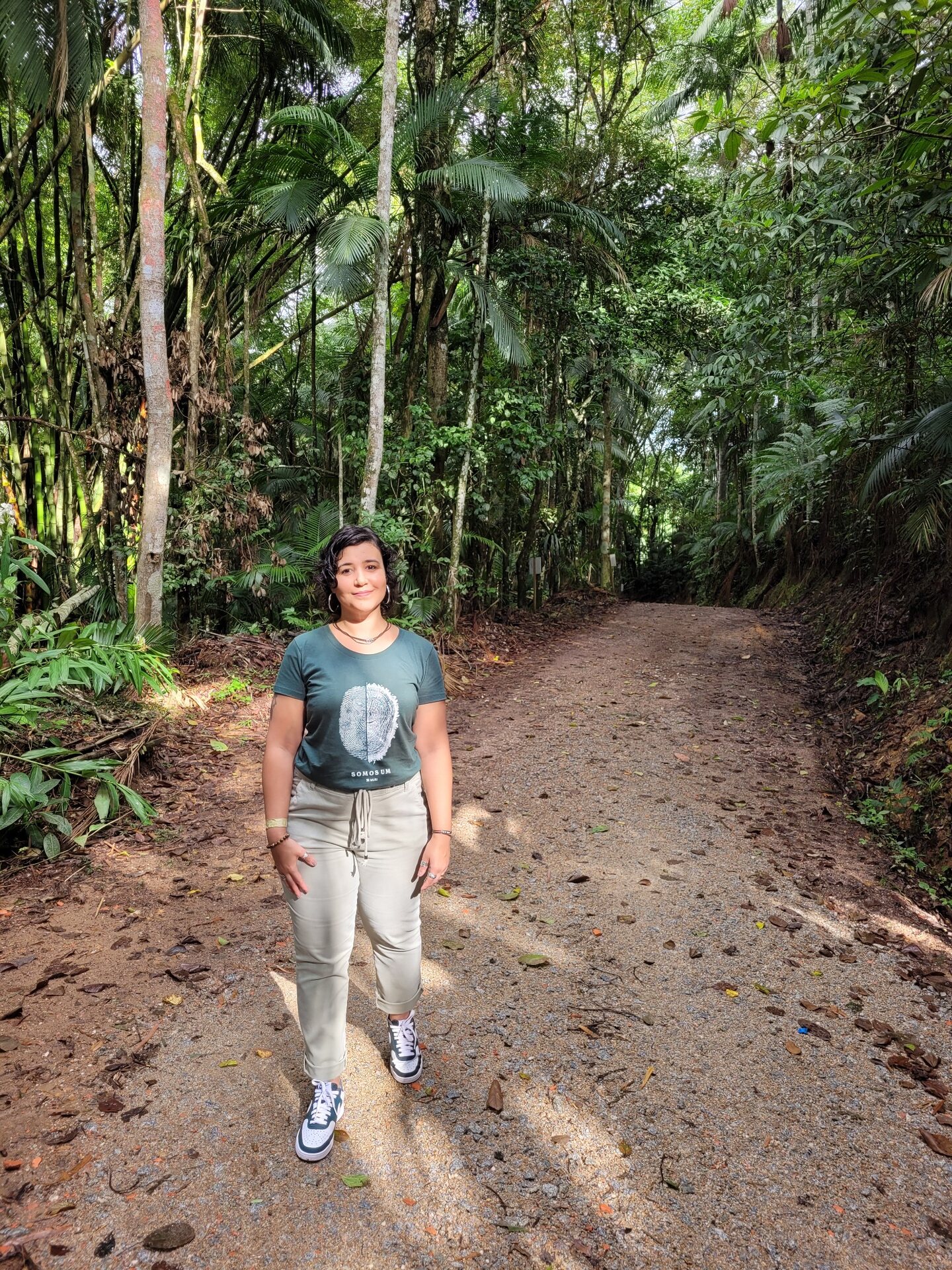Cinthia Rufino caminhando em uma trilha cercada pela natureza